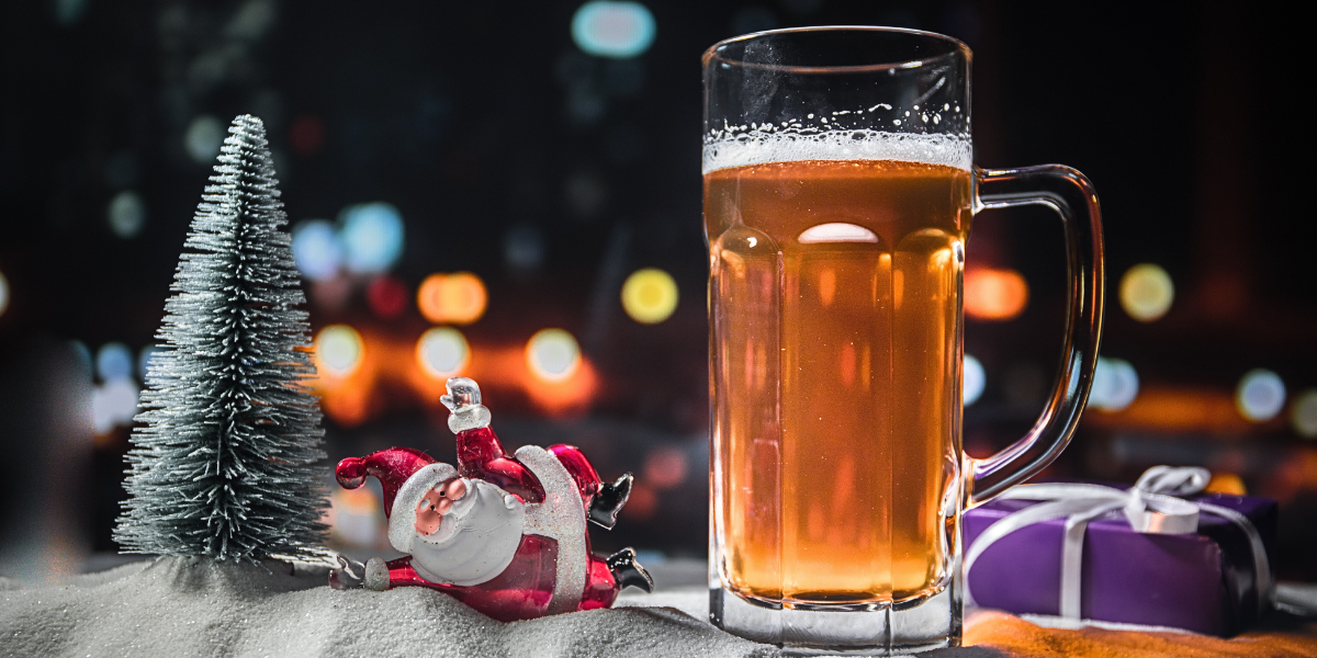 a beer pictured next to a miniature Santa and Christmas tree
