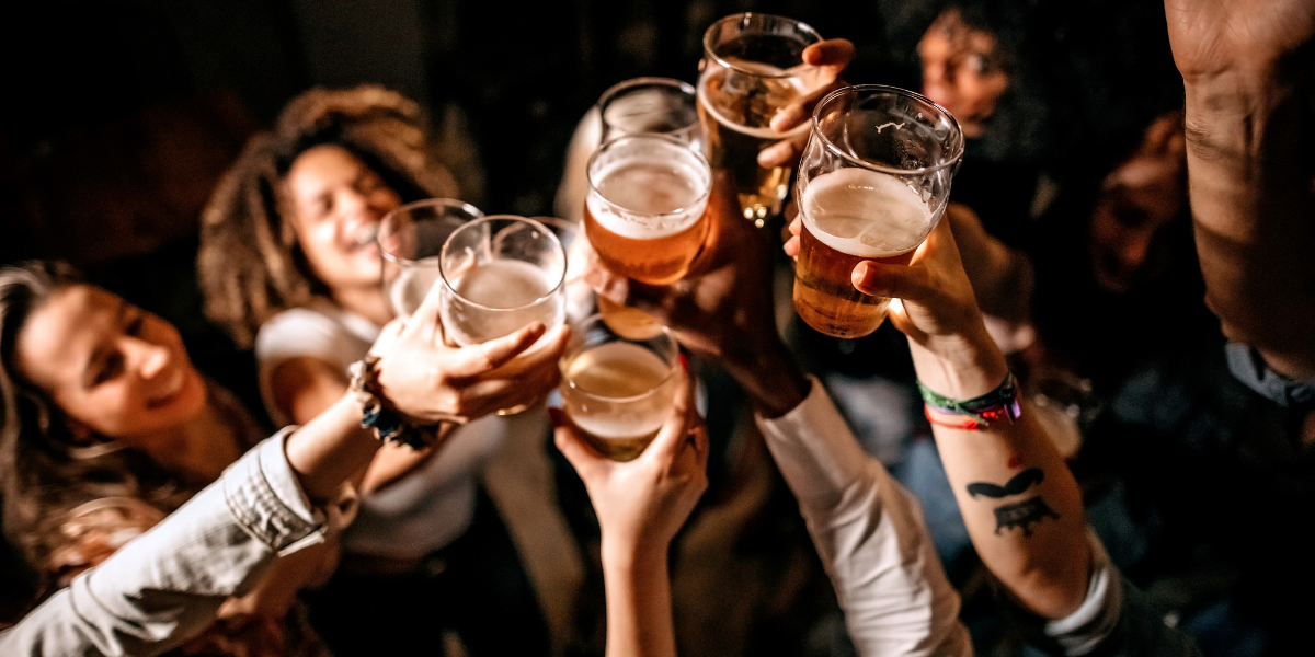 A group of people doing a cheers with their beers 