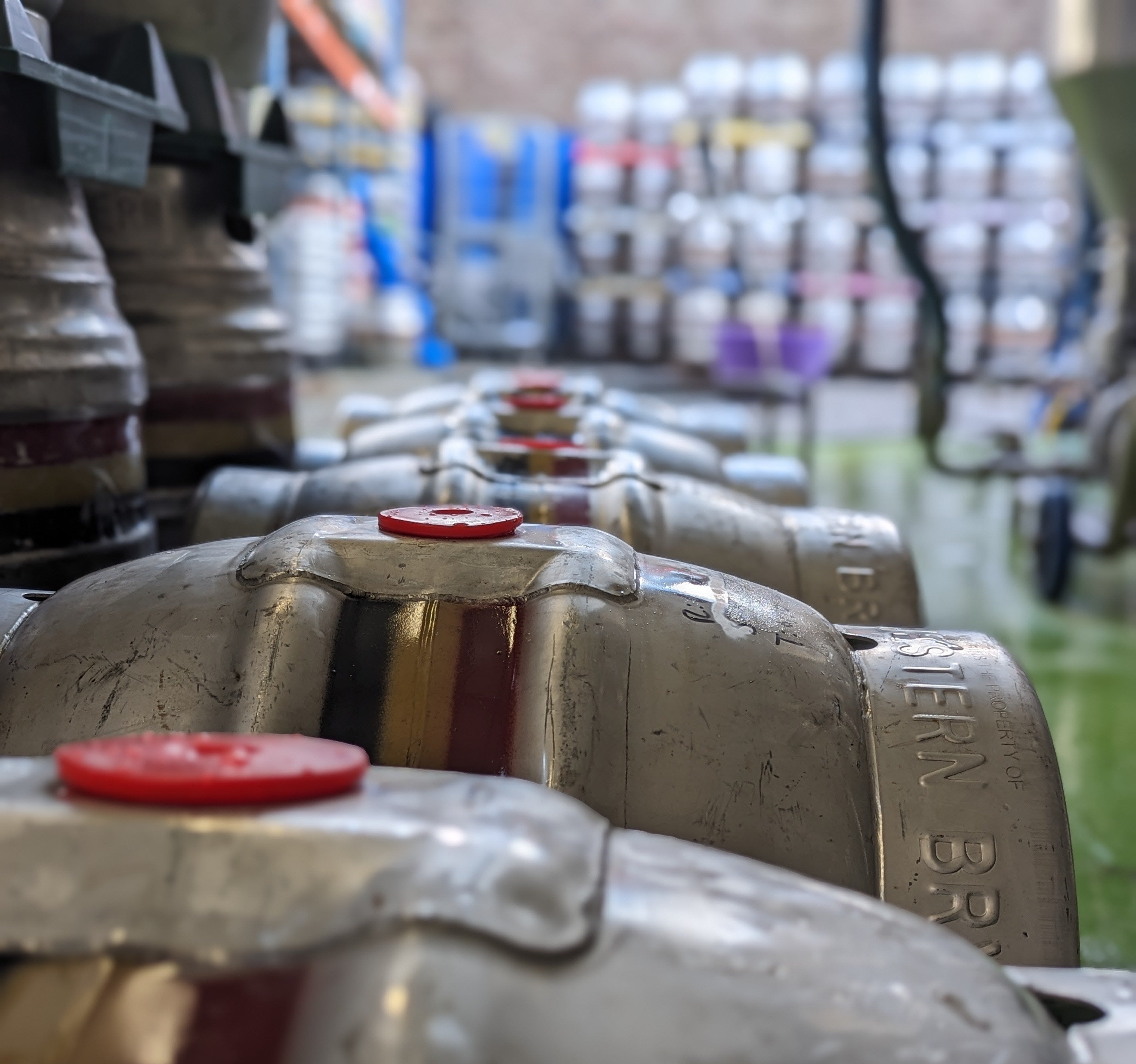 Casks led down side by side in Hop Union Brewery with blurred kegs in the background